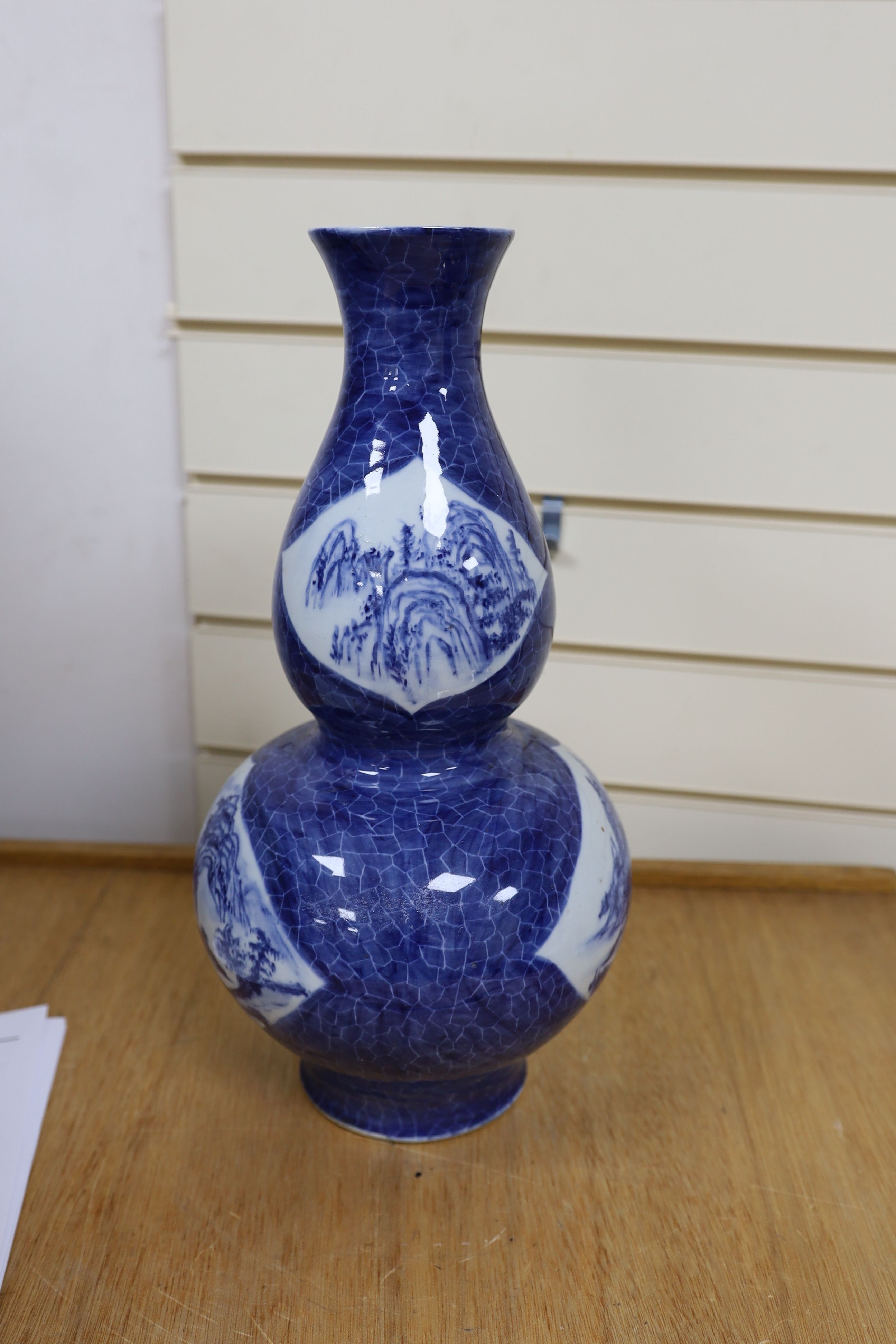 A Chinese blue and white gourd vase with landscape decoration, a similar blue and white sleeve vase and a Japanese Kutani vase